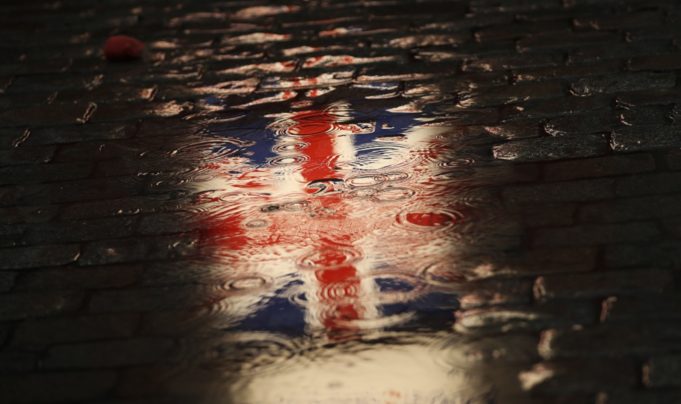 FILE - In this Thursday, Jan. 30, 2020 file photo, the Union flag is reflected in a puddle during an event called "Brussels calling" to celebrate the friendship between Belgium and Britain at the Grand Place in Brussels. Britain and the European Union have struck a provisional free-trade agreement that should avert New Year chaos for cross-border traders and bring a measure of certainty for businesses after years of Brexit turmoil.  (AP Photo/Francisco Seco, File)
