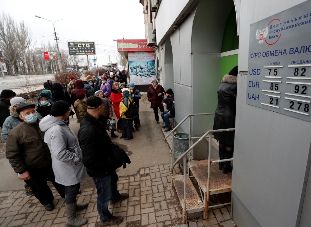 People stand in line to use an ATM money machine, after Russian President Vladimir Putin authorized a military operation in eastern Ukraine, in the separatist-controlled city of Donetsk, Ukraine February 24, 2022. REUTERS/Alexander Ermochenko