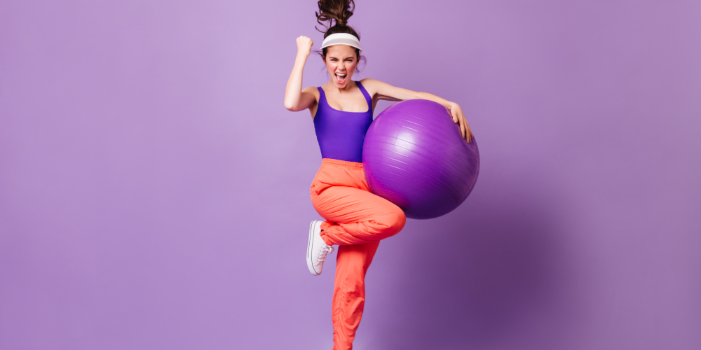 Active,Woman,Happily,Bounces,With,Fitball,On,Purple,Background.,Girl