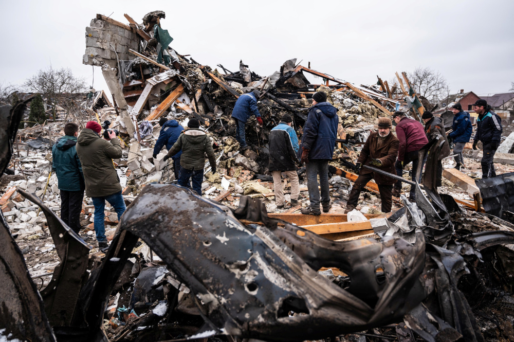 Local residents work among remains of a residential building destroyed by shelling, as Russia's invasion of Ukraine continues, in Zhytomyr, Ukraine March 2, 2022. REUTERS/Viacheslav Ratynskyi