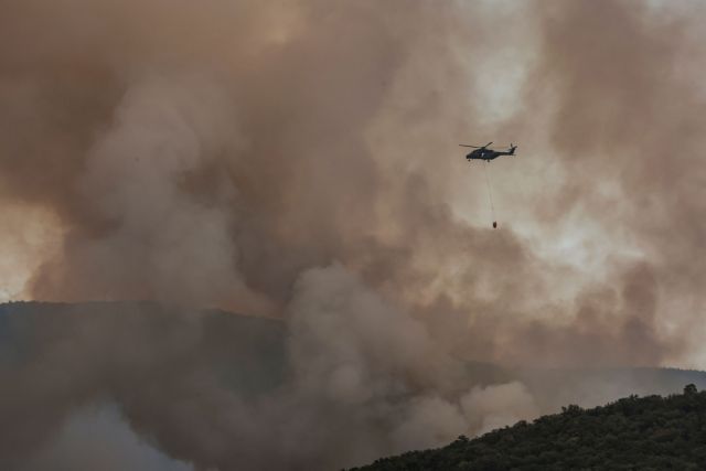A helicopter flies above a wildfire in Jamiano, Italy, July 20, 2022. REUTERS/Borut Zivulovic REFILE - CORRECTING LOCATION AND TYPE OF AN AIRCRAFT