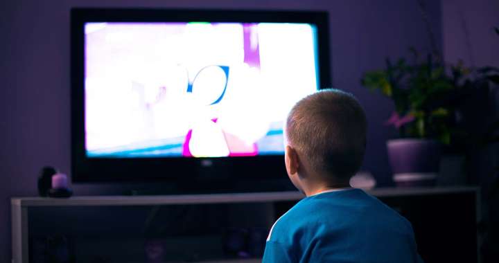 Boy watching television in dark living room